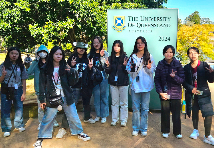 同學在昆士蘭大學校園前合影留念,背景是 The University of Queensland 標誌牌與綠樹環境 | 澳洲遊學團