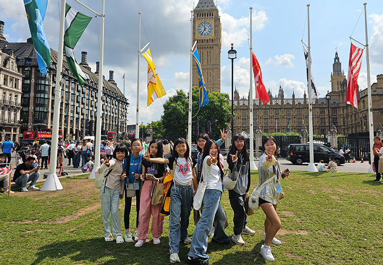 同學團體在倫敦大笨鐘前合照,背景為國會大廈與飄揚旗幟,體驗英國文化 | 英國遊學團