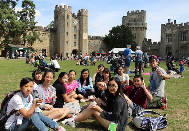 同學們坐在古堡草地上開心吃雪糕,悠閒地享受 Warwick Castle 的中世紀氛圍 | 英國遊學團